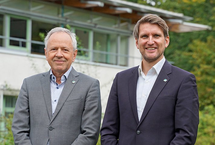 Vorstandsvorsitzender Martin Adel (links) und Vorstand Dr. Martin Holler lächeln in die Kamera.