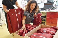 Neue Kleider für Delegation der Johannes-Diakonie steigern bei Sportkoordinatorin Claudia Geiger die Vorfreude auf die Nationalen Spiele von Special Olympics. Sportkoordinatorin Claudia Geiger öffnet Kartons mit Shirts und Jacken für das Team Johannes-Diakonie..